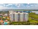 Mediterranean-style condo with a tile roof is surrounded by lush landscaping, a pool, and views of the water at 261 Minorca Beach Way # 406, New Smyrna Beach, FL 32169