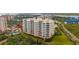 Exterior shot of a Mediterranean-style condo building with a pool, lush landscaping, and stunning views at 261 Minorca Beach Way # 406, New Smyrna Beach, FL 32169