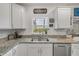 Well-equipped kitchen featuring granite countertops, stainless steel appliances, a double basin sink, and plenty of storage at 2921 India Palm Dr, Edgewater, FL 32141