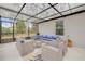 A covered patio features stylish wicker seating with blue cushions, perfect for outdoor relaxation and entertaining at 2921 India Palm Dr, Edgewater, FL 32141