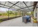 Enclosed patio with a dining set, view of the greenery, and a translucent roof at 2921 India Palm Dr, Edgewater, FL 32141