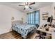 Bright bedroom featuring a floral patterned bed, ceiling fan, and a dedicated workspace with a computer setup at 532 White Coral Ln, New Smyrna Beach, FL 32168