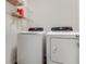 Laundry room featuring modern, white, front-load washing machine and dryer with wire rack shelving at 532 White Coral Ln, New Smyrna Beach, FL 32168