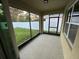 Enclosed back patio featuring screened in windows, concrete flooring, and access to the fenced in backyard at 532 White Coral Ln, New Smyrna Beach, FL 32168
