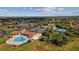 Aerial view of a community pool and tennis courts surrounded by lush greenery at 56 Live Oak Ln, New Smyrna Beach, FL 32168