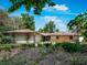 Charming single-story ranch-style home featuring mature trees and well-maintained landscaping at 56 Live Oak Ln, New Smyrna Beach, FL 32168