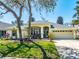 Charming single-story home featuring a manicured lawn, mature landscaping, and attached two-car garage at 5986 Heron Pond Dr, Port Orange, FL 32128