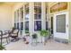 A cozy front porch featuring a seating area with potted plants enhancing the home's curb appeal at 5986 Heron Pond Dr, Port Orange, FL 32128