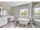 Bright bathroom featuring a soaking tub, walk-in shower, double vanity and wood look flooring at 1012 Bradford Ridge Dr, Leesburg, FL 34748