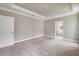 Neutral bedroom features a tray ceiling, recessed lighting, and ensuite bathroom access at 1012 Bradford Ridge Dr, Leesburg, FL 34748