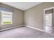 A secondary bedroom with carpet flooring, a window, and access to an adjacent room at 1012 Bradford Ridge Dr, Leesburg, FL 34748