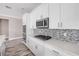 Modern kitchen featuring stainless steel appliances, white cabinets, and mosaic backsplash on the countertops at 1012 Bradford Ridge Dr, Leesburg, FL 34748