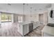 Bright, open kitchen with white cabinets, stainless steel appliances, and a large center island with quartz countertops at 1012 Bradford Ridge Dr, Leesburg, FL 34748