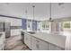 Bright, open kitchen with white cabinets, stainless steel appliances, and a large center island with quartz countertops at 1012 Bradford Ridge Dr, Leesburg, FL 34748