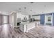 Bright, open kitchen with white cabinets, stainless steel appliances, and a large center island with quartz countertops at 1012 Bradford Ridge Dr, Leesburg, FL 34748