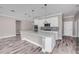 Bright, open kitchen with white cabinets, stainless steel appliances, and a large center island with quartz countertops at 1012 Bradford Ridge Dr, Leesburg, FL 34748