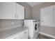 Bright laundry room featuring a modern washer and dryer and ample cabinets with quartz countertops at 1012 Bradford Ridge Dr, Leesburg, FL 34748
