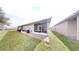 View of a backyard featuring a screened lanai and well-maintained lawn, perfect for outdoor relaxation at 106 Tuscany Villas Dr # 0160, Edgewater, FL 32141