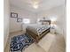 Bedroom with nautical themed rug, wooden bed frame, white walls and ceiling fan at 106 Tuscany Villas Dr # 0160, Edgewater, FL 32141