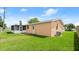 A grassy backyard featuring a screened-in porch with a quaint single-story home in the background at 121 Ellicott Dr, Ormond Beach, FL 32176