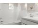 Bright white bathroom featuring a shower and tub combo, stylish light fixture, and neutral decor at 121 Ellicott Dr, Ormond Beach, FL 32176