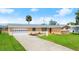 Charming single-story home features a well-maintained lawn, a two-car garage, and a classic concrete driveway at 121 Ellicott Dr, Ormond Beach, FL 32176