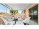 An enclosed porch is furnished with stylish white wicker furniture and has sliding door access to the home at 121 Ellicott Dr, Ormond Beach, FL 32176