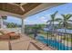 Balcony view features a pool, waterfront views, palm trees, and lounge furniture at 1212 Commodore Dr, New Smyrna Beach, FL 32168