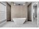 This is a large bathroom with a walk-in shower, stand alone tub, and marble floors at 1212 Commodore Dr, New Smyrna Beach, FL 32168