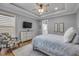 Relaxing bedroom with a mounted TV, patterned armchair, and a comfortable bed with soft lighting at 1212 Commodore Dr, New Smyrna Beach, FL 32168