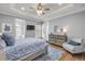 Bright bedroom with a blue and white patterned bedspread, decorative rug, and a dresser with mirror at 1212 Commodore Dr, New Smyrna Beach, FL 32168