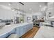 A luxury kitchen featuring an island with seating and stainless-steel appliances that opens into the dining room at 1212 Commodore Dr, New Smyrna Beach, FL 32168