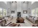 Symmetrical living room featuring a fireplace, large windows, and stylish furnishings for a cozy atmosphere at 1212 Commodore Dr, New Smyrna Beach, FL 32168