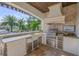 Covered outdoor kitchen with stainless steel grill, sink, and storage, perfect for al fresco dining at 1212 Commodore Dr, New Smyrna Beach, FL 32168