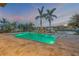 Beautiful backyard pool with a view of the canal, palm trees, and stylish tile decking, perfect for outdoor relaxation at 1212 Commodore Dr, New Smyrna Beach, FL 32168