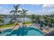 This aerial view highlights the pool area featuring waterfront views, a gazebo, and lounge furniture at 1212 Commodore Dr, New Smyrna Beach, FL 32168