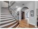 Elegant staircase with hardwood steps, a wrought iron railing, and a wine cellar at 1212 Commodore Dr, New Smyrna Beach, FL 32168
