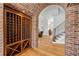 Close-up of a wooden wine rack and the entry to the room through a brick archway at 1212 Commodore Dr, New Smyrna Beach, FL 32168