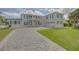 Stunning two-story home featuring a stone driveway, two-car garage, and a second-story balcony with waterfront views at 1221 Commodore Dr, New Smyrna Beach, FL 32168