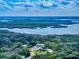 Scenic aerial shot showcasing a property with a circular driveway, lush landscaping, and waterfront views in a serene setting at 133 Cedar Dunes Dr, New Smyrna Beach, FL 32169