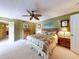 Spacious bedroom with fan, dresser, wood accents, and adjoining bathroom at 133 Cedar Dunes Dr, New Smyrna Beach, FL 32169
