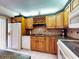 Traditional kitchen with wooden cabinets, white appliances, and tiled backsplash, blending style with functionality at 133 Cedar Dunes Dr, New Smyrna Beach, FL 32169
