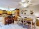 Open kitchen showcases bright tile floor, island seating, and decorative fan, connecting dining and cooking spaces at 133 Cedar Dunes Dr, New Smyrna Beach, FL 32169