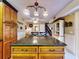 Kitchen island with granite countertops and wooden cabinets, complemented by elegant chandelier lighting at 133 Cedar Dunes Dr, New Smyrna Beach, FL 32169