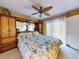 Comfortable bedroom with large bed, ceiling fan, and access to a private outdoor space at 133 Cedar Dunes Dr, New Smyrna Beach, FL 32169