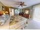 Inviting green main bedroom with ceiling fan, mirrors, king bed, and a view of the sliding glass door at 133 Cedar Dunes Dr, New Smyrna Beach, FL 32169