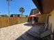 Brick patio with outdoor seating area, red umbrella, and wooden fence, perfect for enjoying the outdoors at 133 Cedar Dunes Dr, New Smyrna Beach, FL 32169