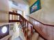 Inviting staircase with wooden railing, carpeted steps, and decorative artwork, creating an appealing transition to upper level at 133 Cedar Dunes Dr, New Smyrna Beach, FL 32169