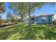 Lush backyard with a wooden dock, mature trees, and a view of the house with a screened lanai at 1363 Wayne Ave, New Smyrna Beach, FL 32168
