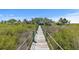 Wooden dock with rope railing and lush greenery leading to home at 1363 Wayne Ave, New Smyrna Beach, FL 32168